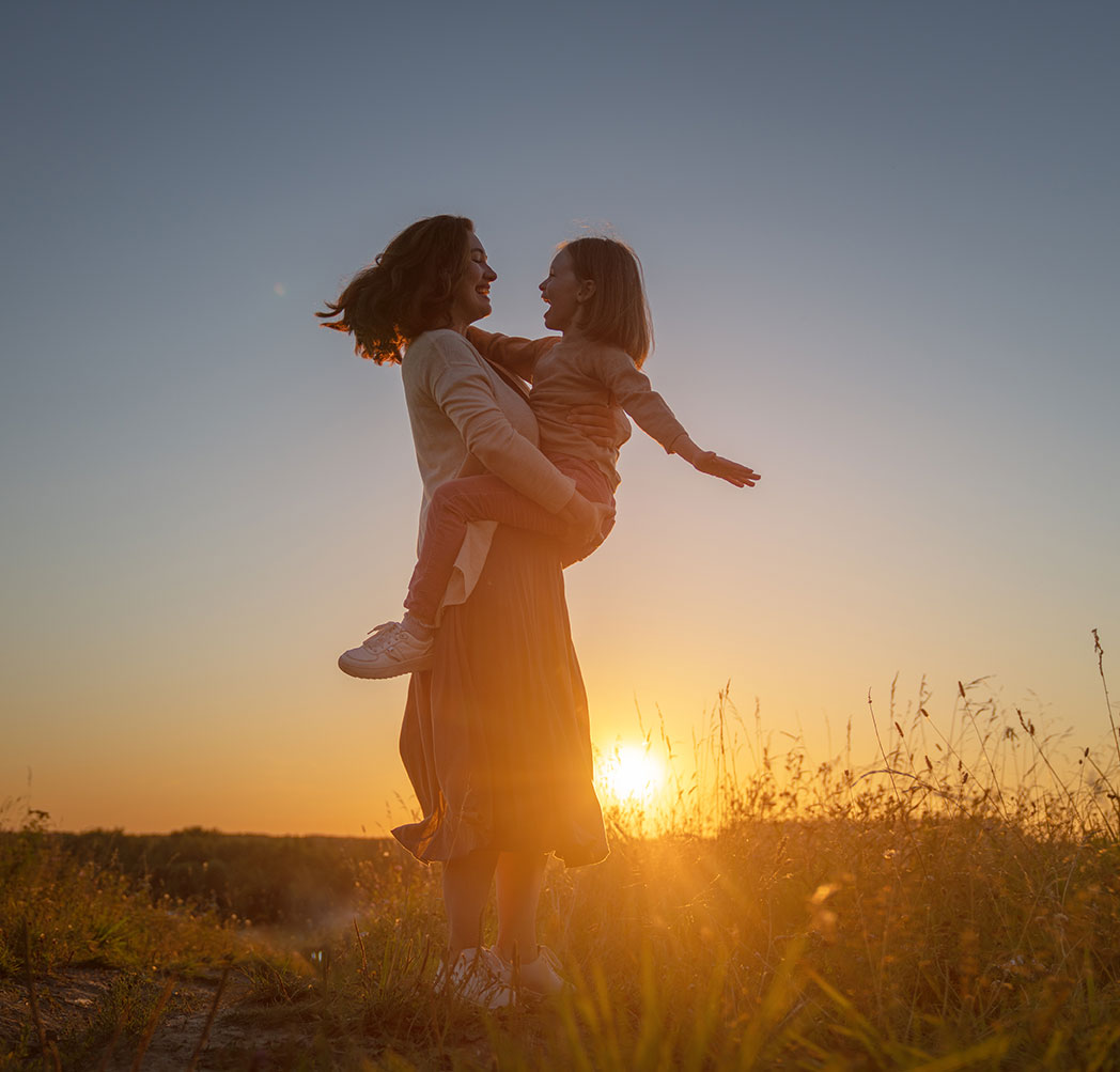 Mutter mit Kind im Sonnenuntergang